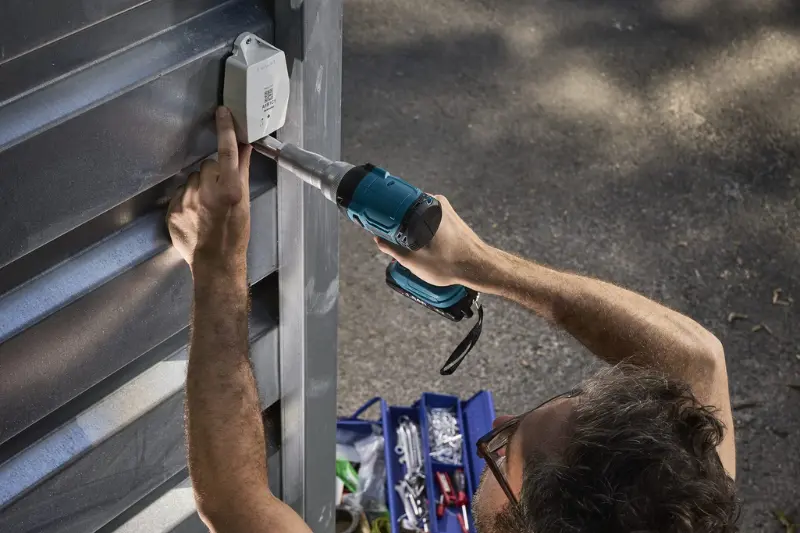 installing a sensolus tracker on a container with a drill