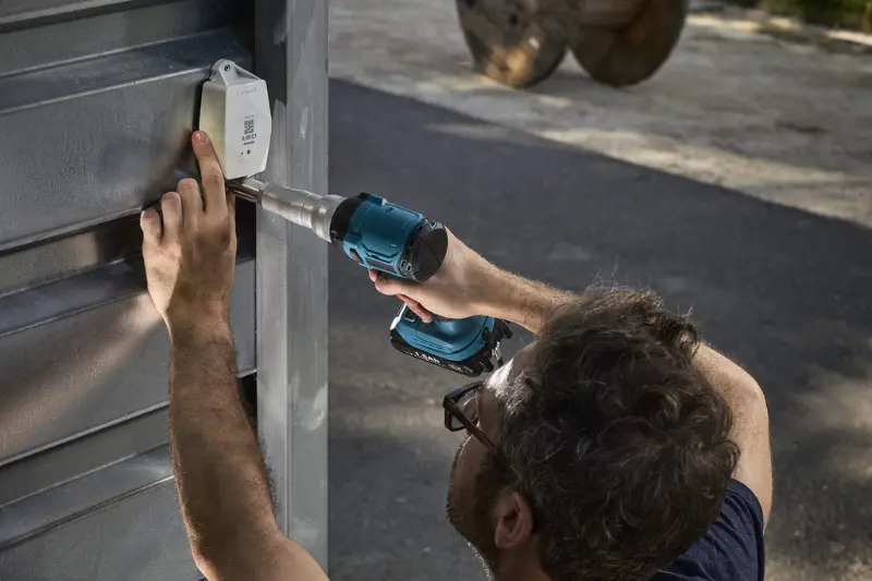 installing a sensolus tracker on a container with a drill
